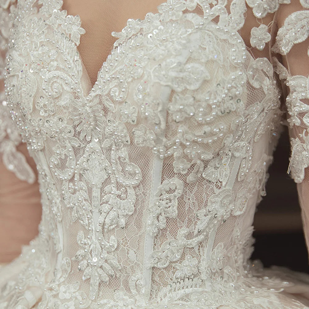 Robe de mariée en dentelle, perles et manches longues – CLEVI Paris